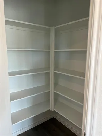 a view of walk in closet with empty racks