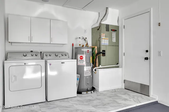 a utility room with cabinets washer and dryer