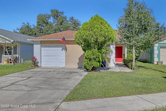 a front view of a house with a yard and a garage