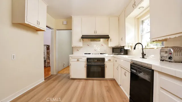 a kitchen with white cabinets and white appliances