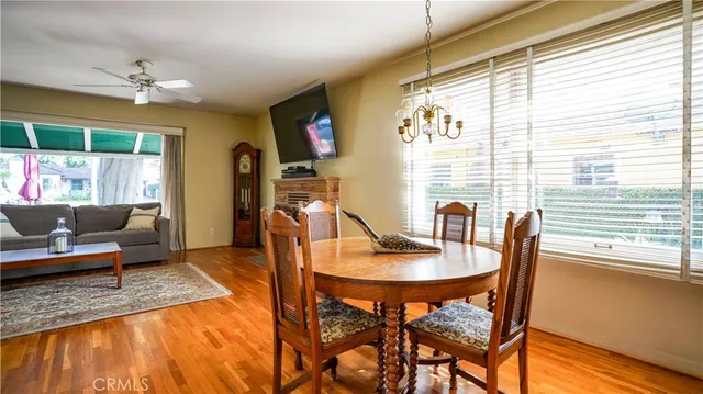 a view of a dining room with furniture a chandelier and wooden floor