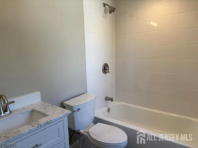 a white toilet and tub sitting next to a bathroom sink