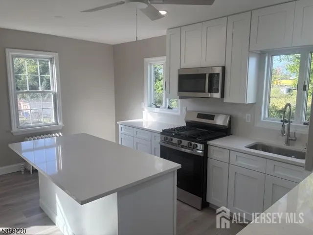 a kitchen with a stove a sink and a microwave