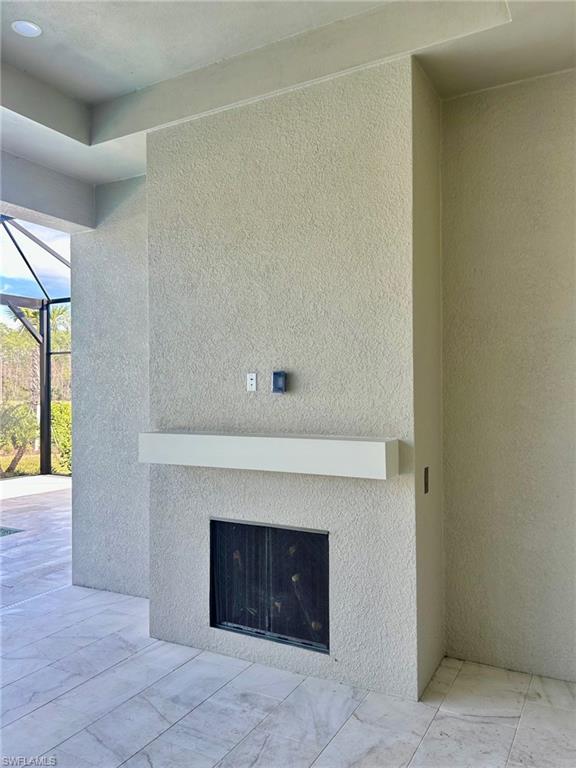 9475 Caymas Way Naples, FL 34114 - Photo 2 of 8 a living room with a fireplace and a ceiling fan
