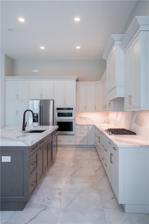 9475 Caymas Way Naples, FL 34114 - Photo 6 of 8 a large kitchen with stainless steel appliances granite countertop a sink and cabinets