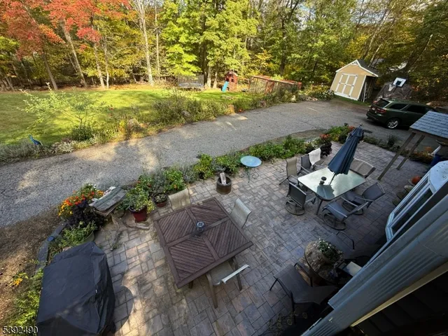 a kitchen with stainless steel appliances granite countertop wooden cabinets a refrigerator a sink and dishwasher a stove with wooden floor