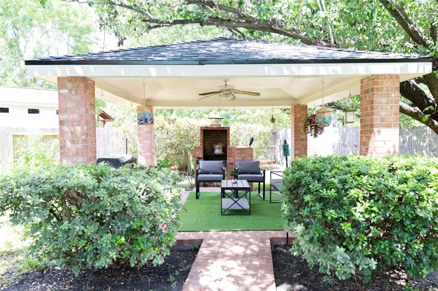a view of a patio with table and chairs potted plants and large tree