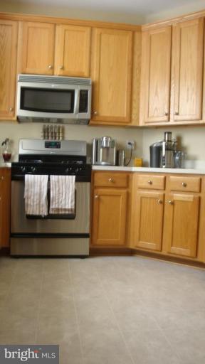 17567 Deweys Run Lane Dumfries, VA 22026 - Photo 7 of 20 a kitchen with stainless steel appliances granite countertop a stove a microwave and a sink