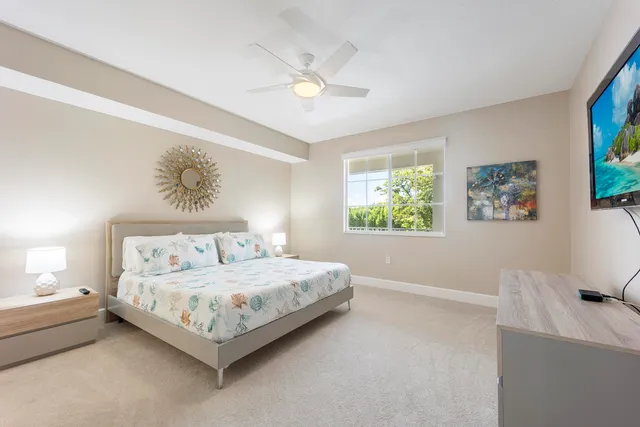 a bedroom with a bed a window and painting on the wall