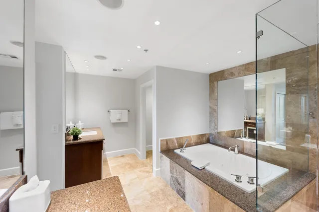 a bathroom with a tub sink and mirror