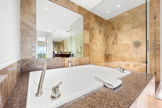 a spacious bathroom with a tub shower and mirror