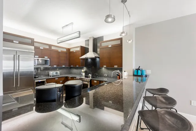 a kitchen with stainless steel appliances granite countertop a sink a stove and a refrigerator