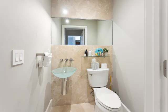 a bathroom with a granite countertop toilet a sink and a mirror