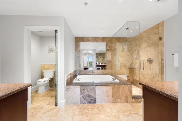 a large bathroom with a granite countertop sink a toilet and shower