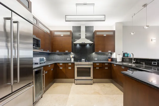 a kitchen with stainless steel appliances granite countertop a stove a sink and a refrigerator