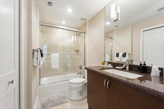a bathroom with a granite countertop sink toilet and shower