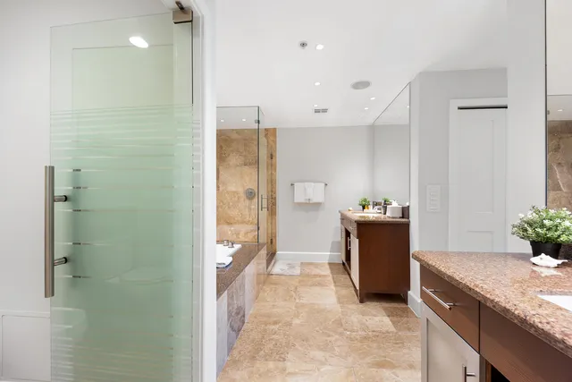 a bathroom with a granite countertop sink a mirror and a shower