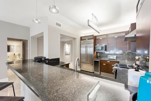 a kitchen with stainless steel appliances granite countertop a sink a stove and a refrigerator