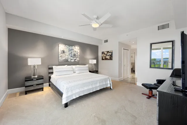 a spacious bedroom with a large bed and a chandelier