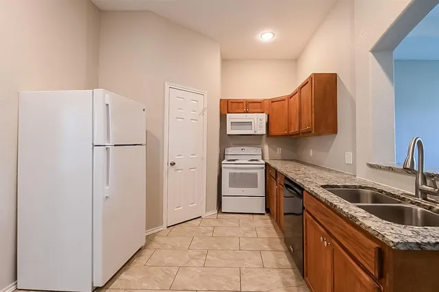 a kitchen with stainless steel appliances granite countertop a refrigerator sink and stove
