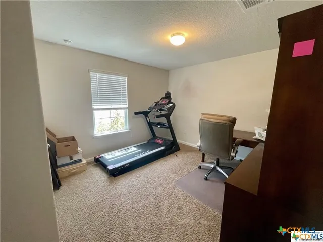 a view of a workspace with furniture and a window