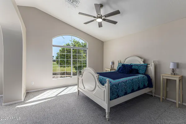 a bed sitting in a spacious bedroom next to a window
