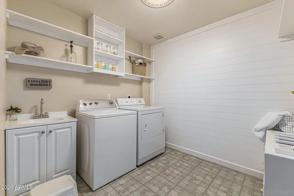 a utility room with cabinets washer and dryer