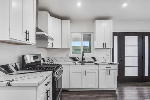 a kitchen with stainless steel appliances granite countertop a sink stove a refrigerator and cabinets
