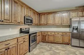 a kitchen with stainless steel appliances granite countertop a stove a sink and a microwave