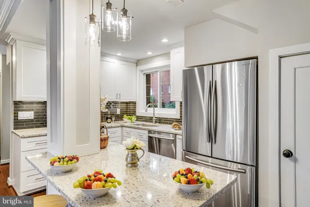 a kitchen with stainless steel appliances granite countertop a refrigerator and a sink