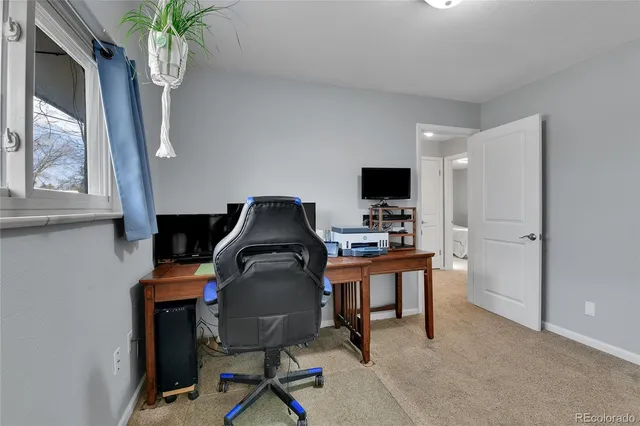 a view of a workspace with furniture and a window