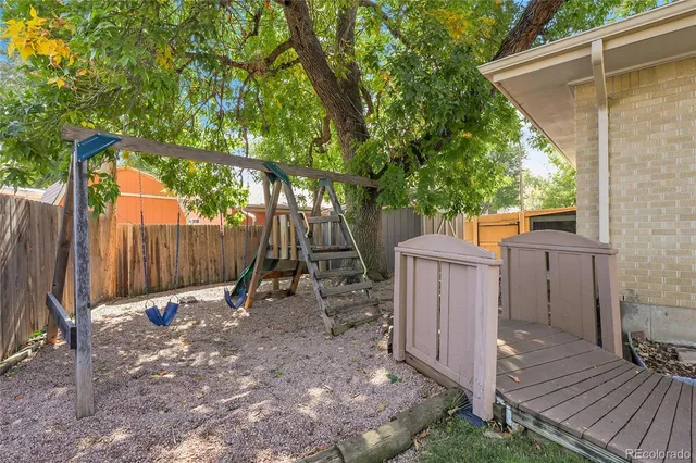 a backyard of a house with a small barn and wooden fence