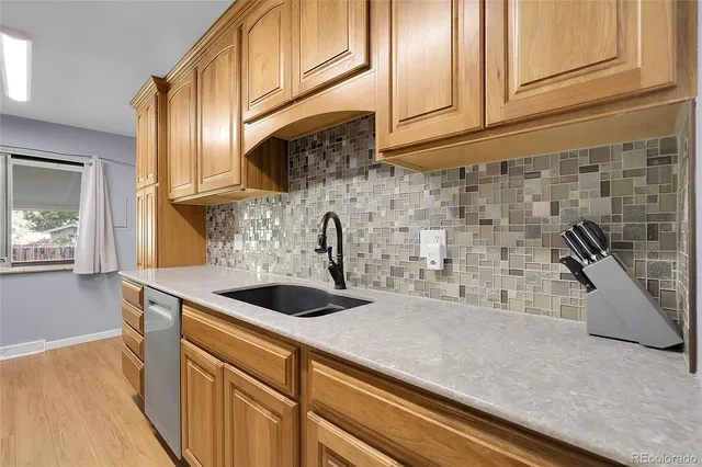 a kitchen with stainless steel appliances granite countertop a sink a stove and cabinets