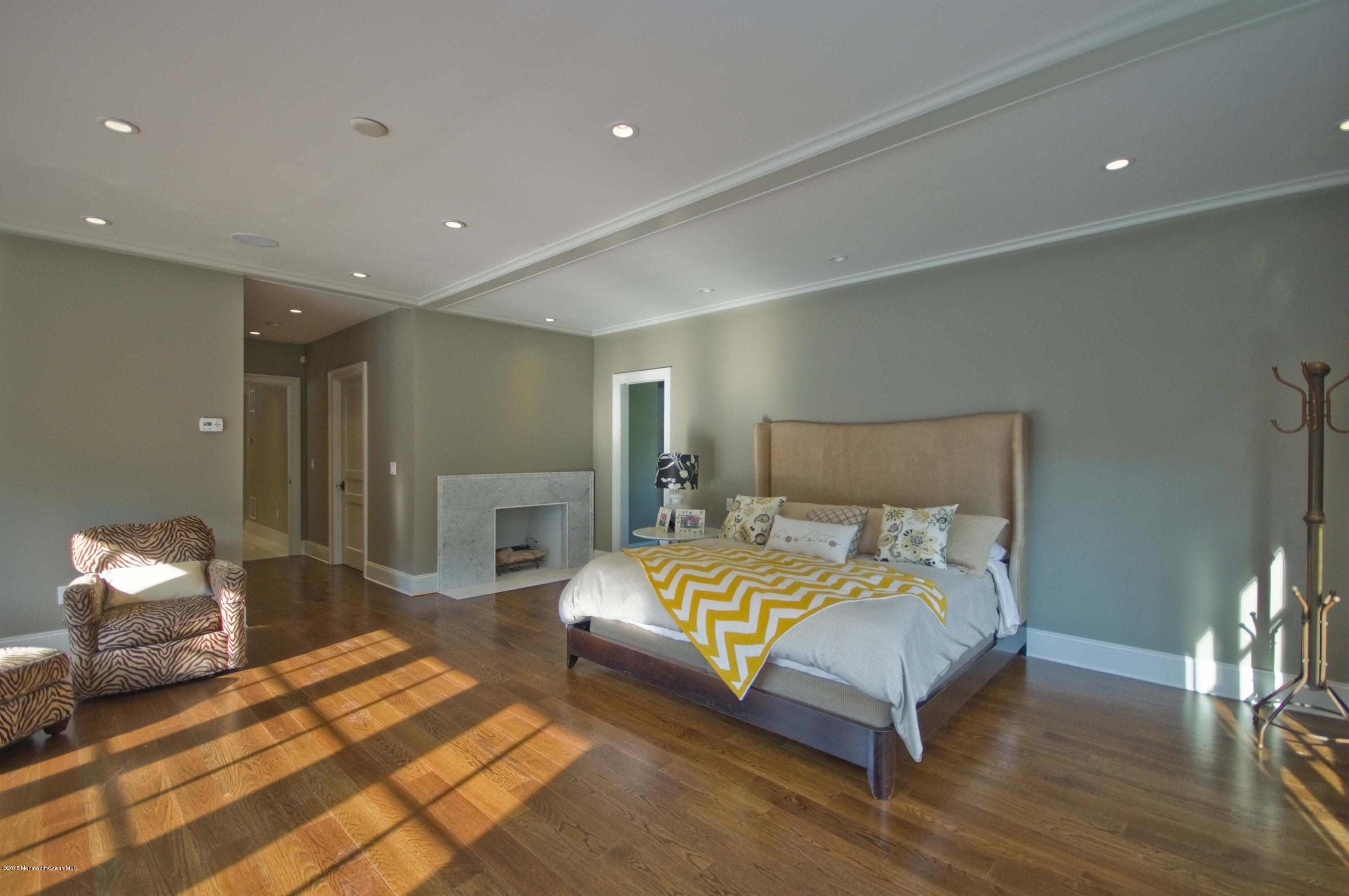 51 Phalanx Road Colts Neck, NJ 07722 - Photo 14 of 35 a bedroom with a bed and a lamp with wooden floor