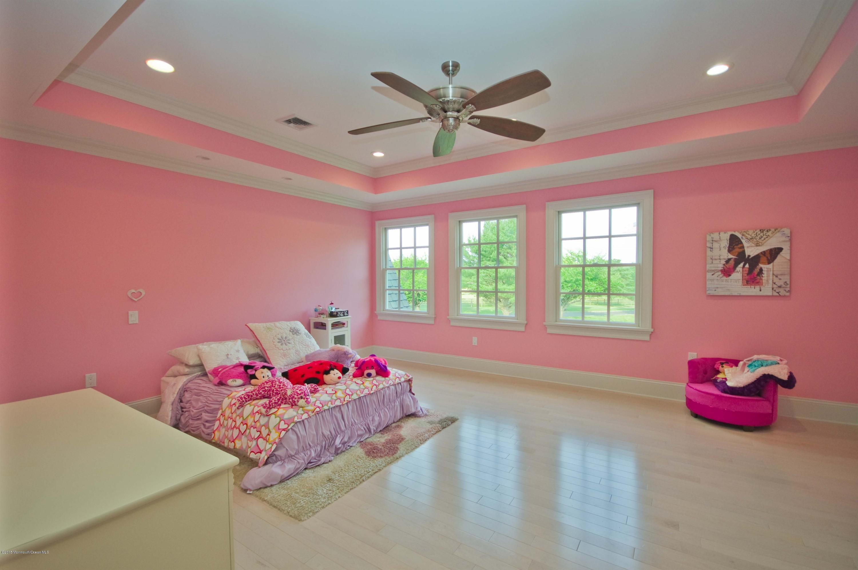 51 Phalanx Road Colts Neck, NJ 07722 - Photo 22 of 35 a bedroom with a bed and a chandelier