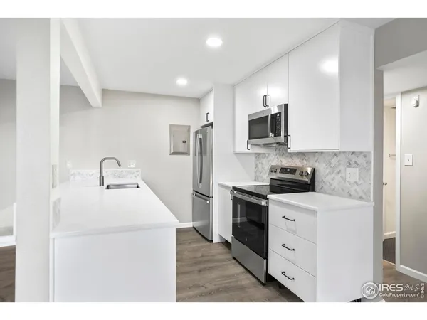a kitchen with a sink a stove top oven and refrigerator