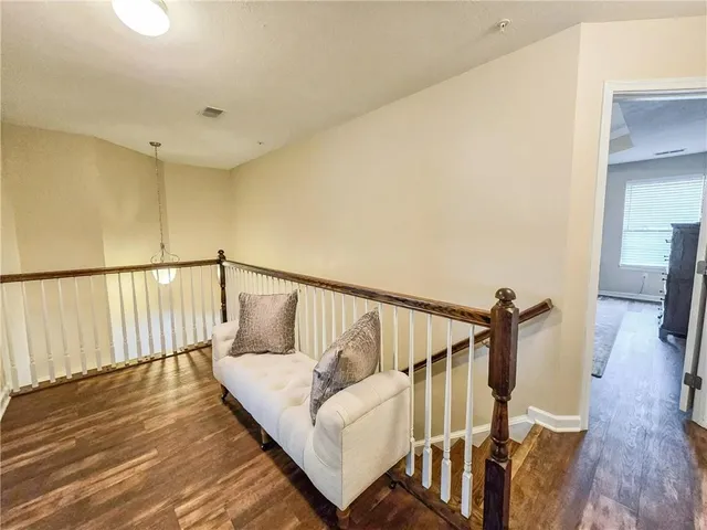 a view of a hallway with wooden floor and stairs