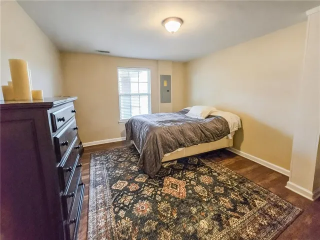a spacious bedroom with a bed and wooden floor