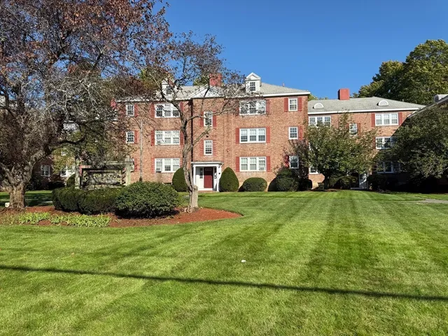 a view of a big building with big yard and large trees