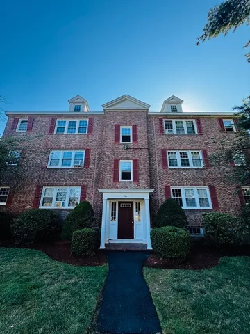 a front view of a house with yard and green space