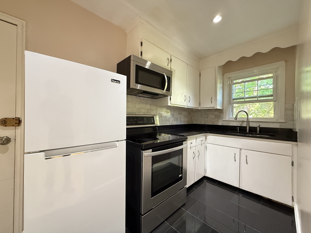 1 Dexter Street, Unit 5 Malden, MA 02148 - Photo 5 of 17 a kitchen with stainless steel appliances a sink cabinets and a window
