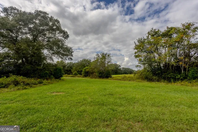 a view of a green field with wooden fence