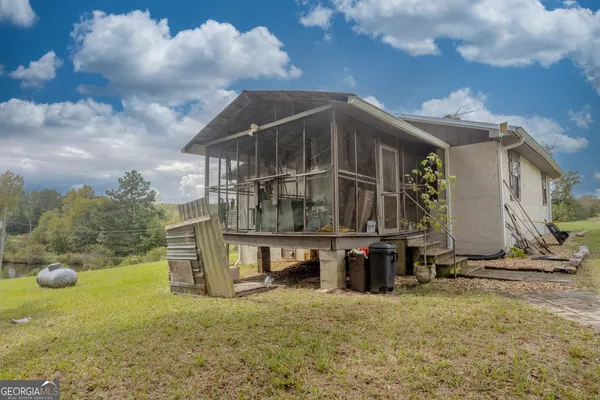 a view of a house with backyard and sitting area
