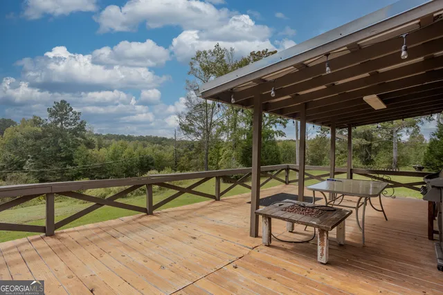 a roof deck with table and chairs under an umbrella with wooden floor
