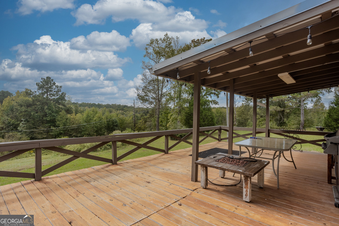 2141 Ebenezer Road Ellaville, GA 31806 - Photo 7 of 50 a roof deck with table and chairs under an umbrella with wooden floor