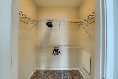 a view of walk in closet with empty racks