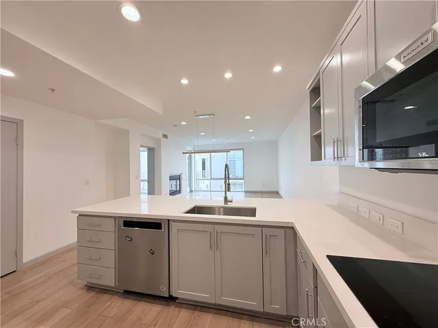 a large kitchen with stainless steel appliances granite countertop a lot of counter space and wooden floors