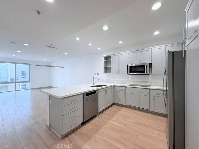 a kitchen with kitchen island a counter top space a sink and refrigerator