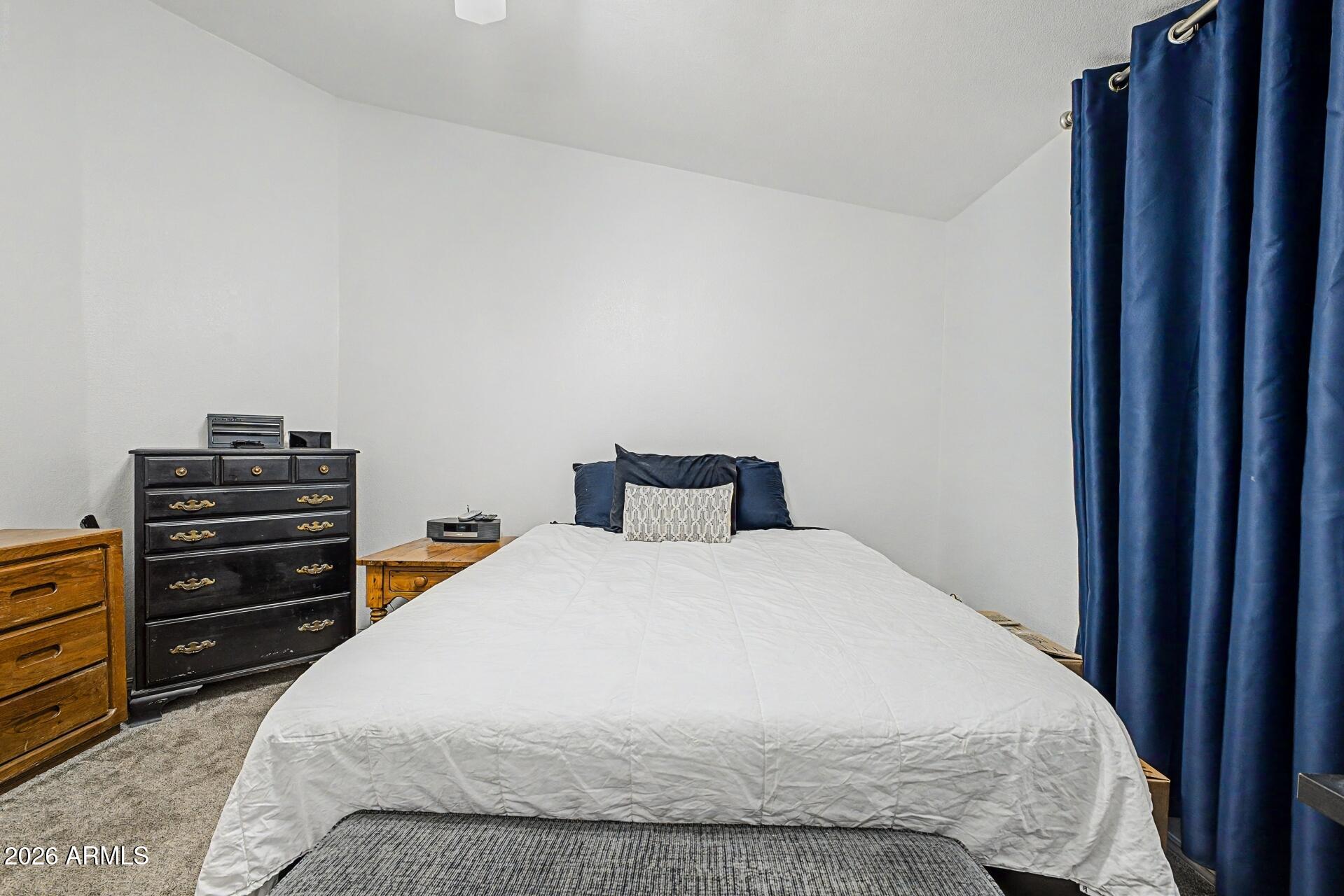2550 South Ellsworth Road, Unit 46 Mesa, AZ 85209 - Photo 23 of 47 a large bed sitting in a bedroom next to a cabinet
