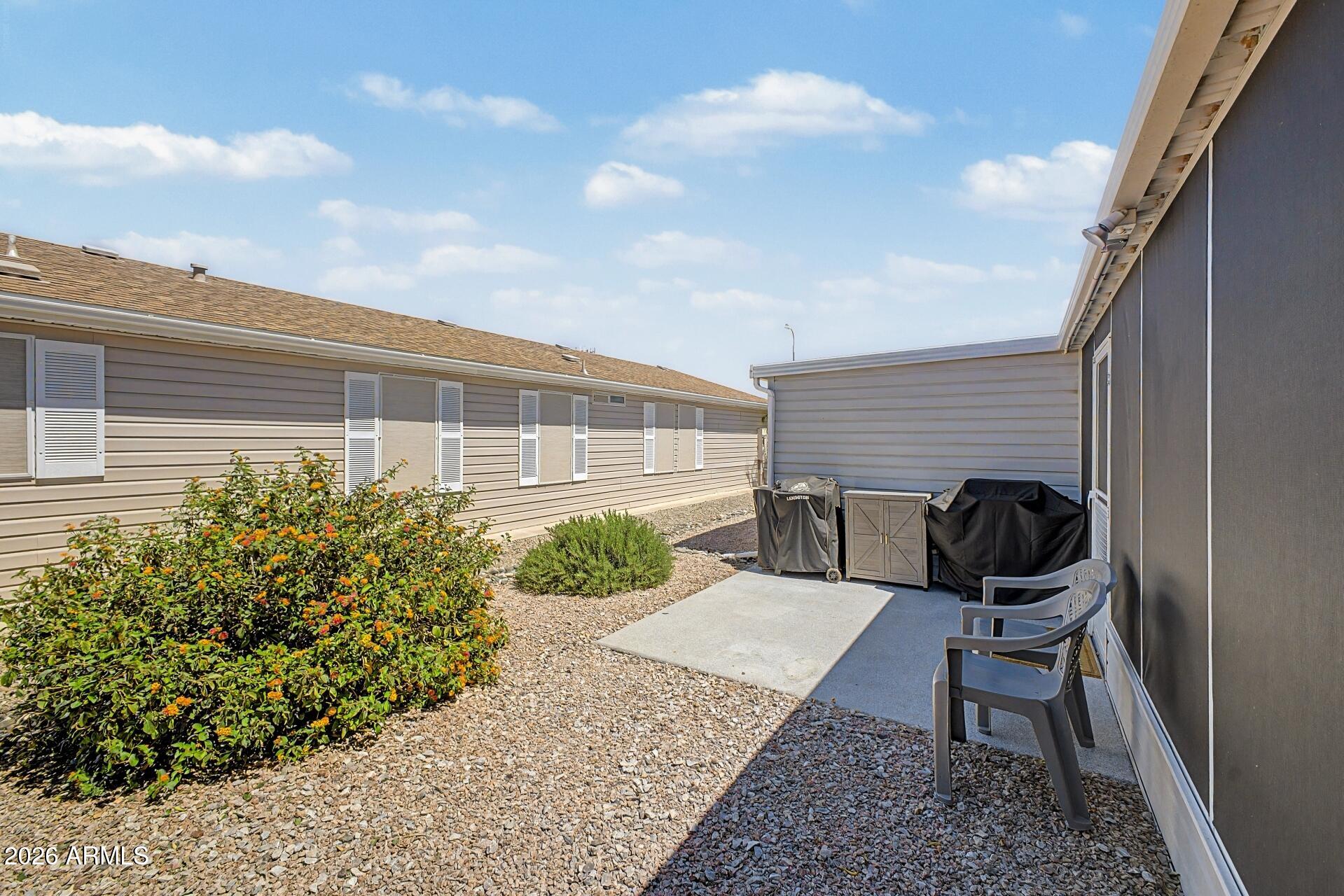 2550 South Ellsworth Road, Unit 46 Mesa, AZ 85209 - Photo 32 of 47 a view of a backyard with chair and potted plants
